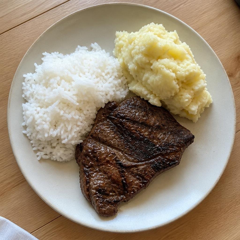 Foto de um prato com arroz, carne e purê